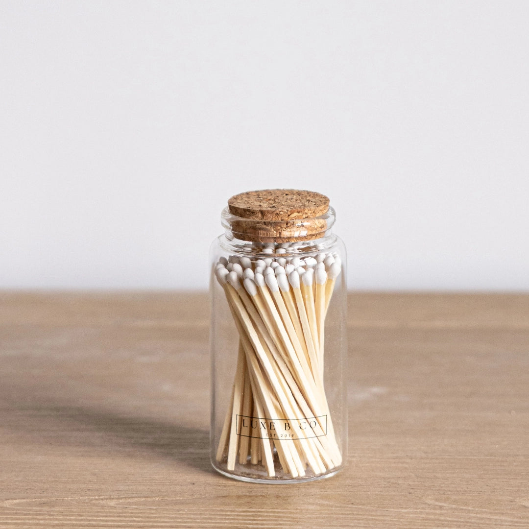 Jar of matches with a cork lid on a wooden surface