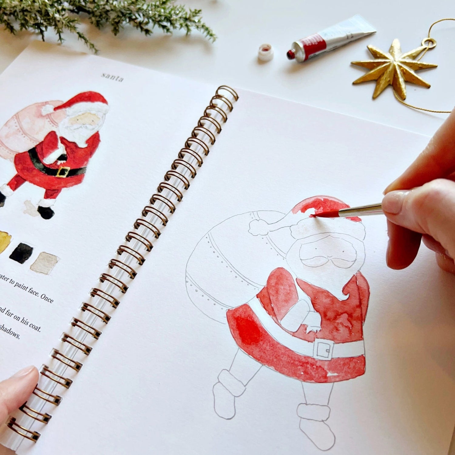 Person coloring a Santa Claus illustration in a coloring book with a paintbrush.