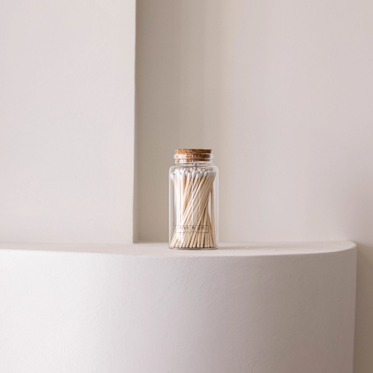 Jar of matches on a white surface with a neutral background