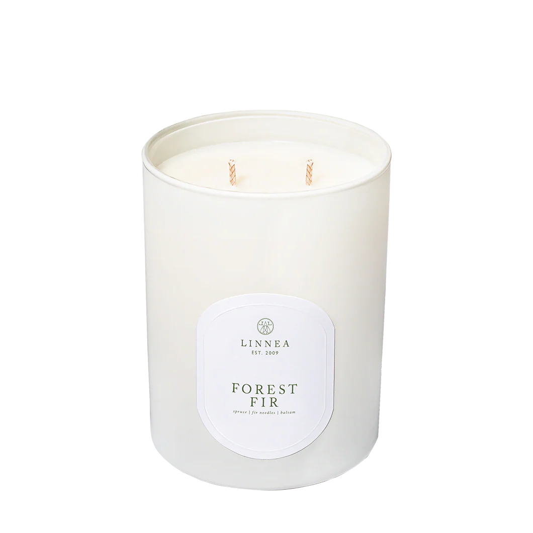 White candle with 'LINNEA' label on a white background