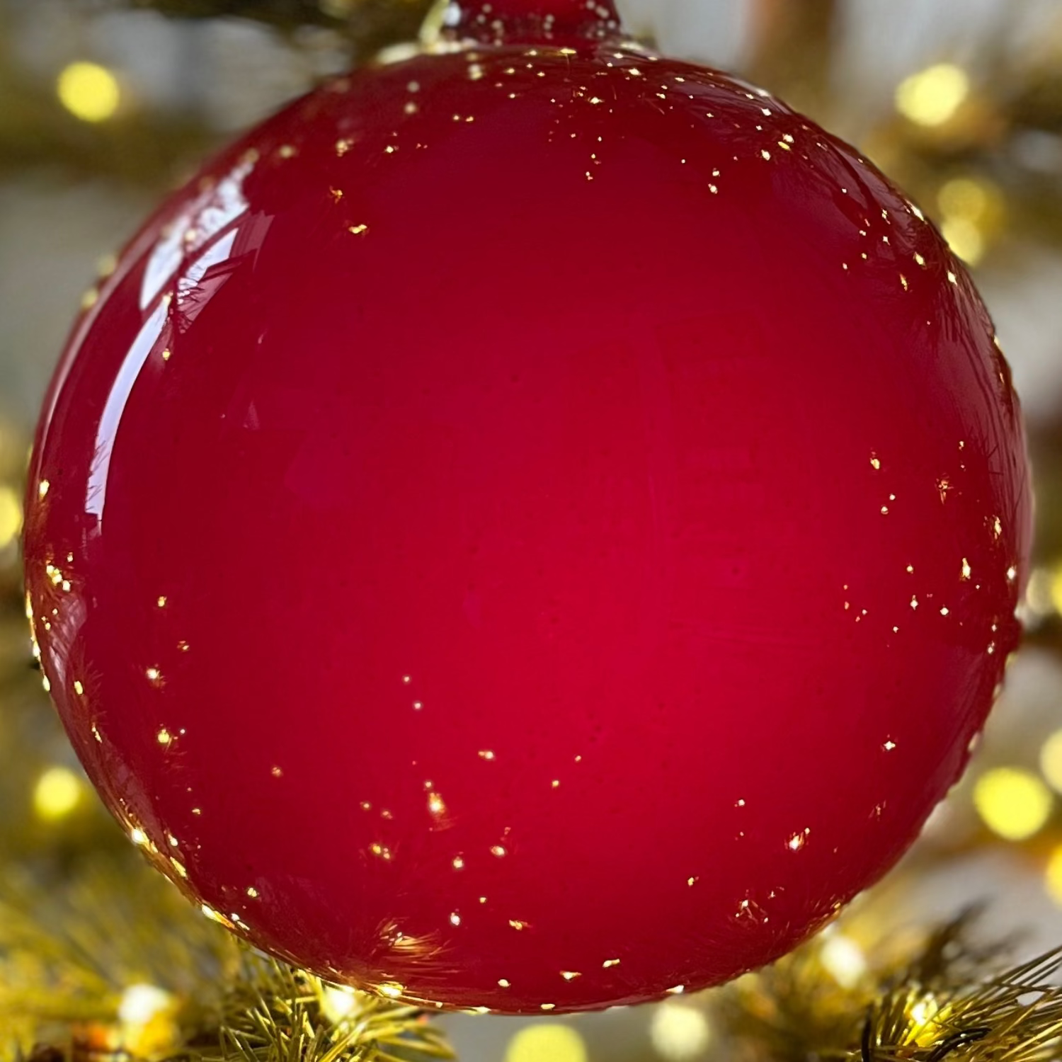 Red ornament on a decorated Christmas tree with lights