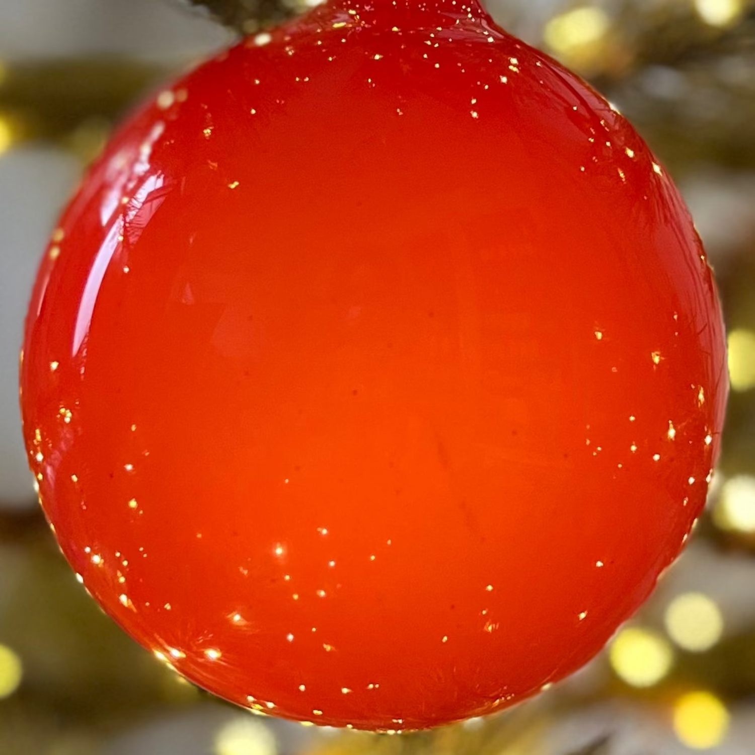 Red ornament on a decorated Christmas tree with lights
