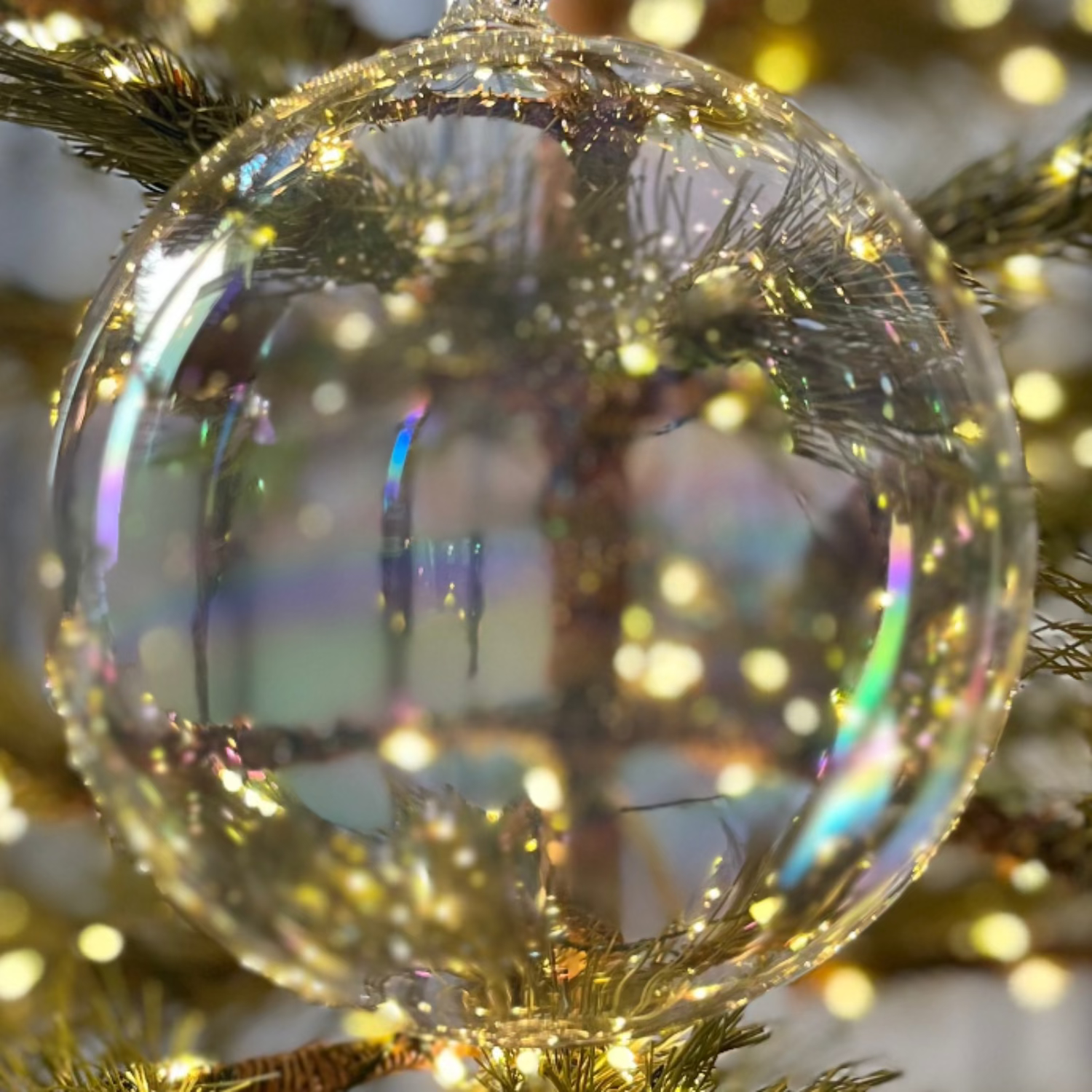 Clear Christmas ornament on a decorated tree with lights