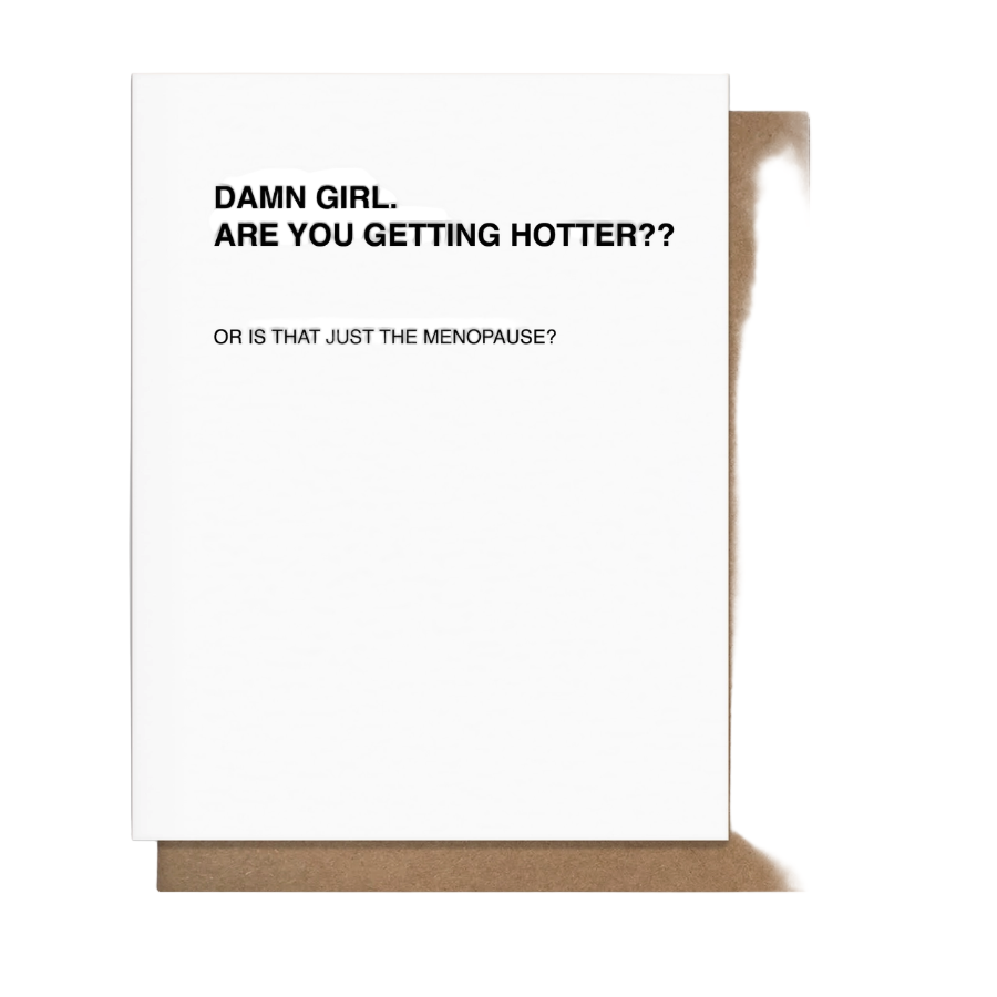 A greeting card with a white background and text that reads 'DAMN GIRL. Are you getting hotter? Or that menopause?' along with a kraft paper envelope.