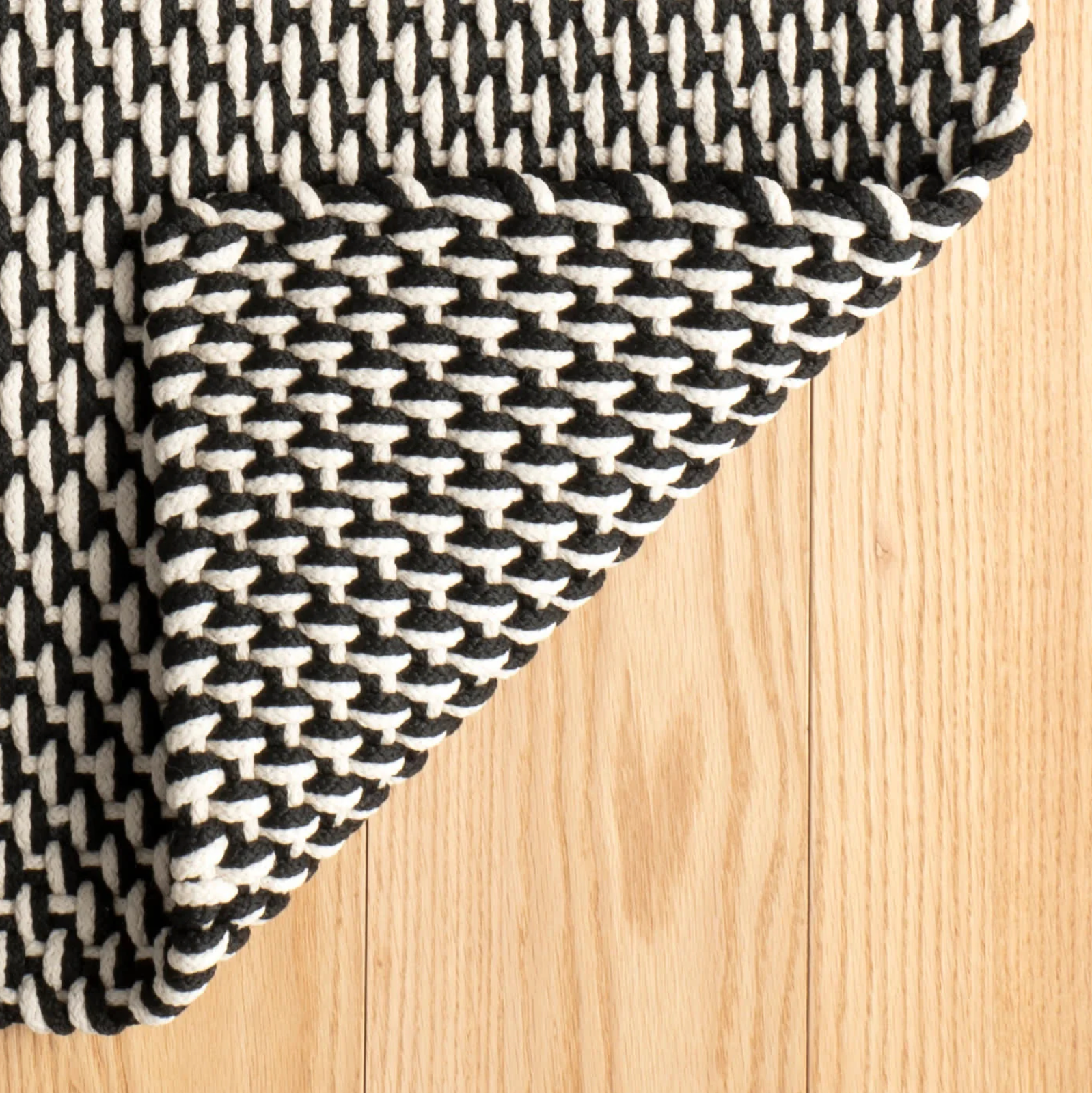 Black and white woven fabric on a wooden surface