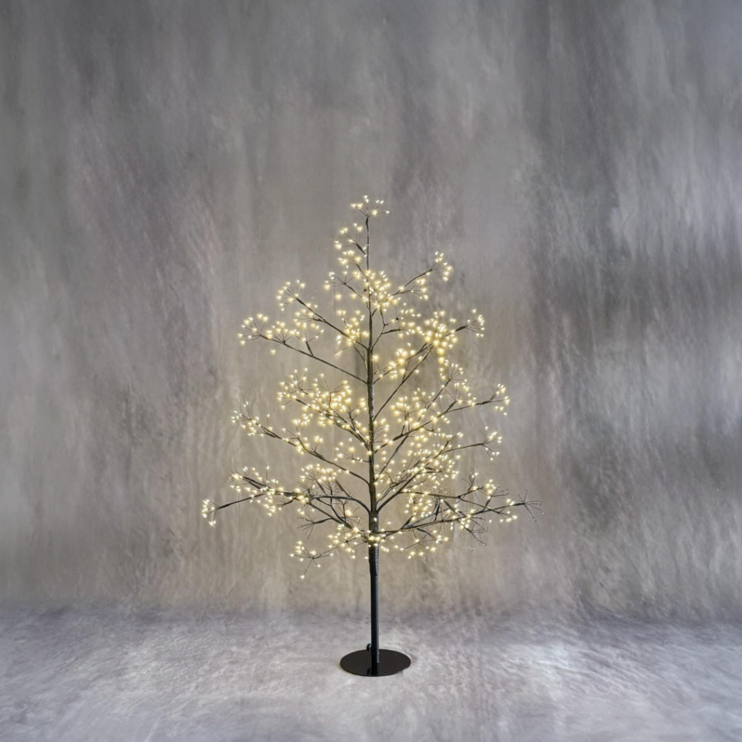 Decorative LED tree with lights against a textured gray background