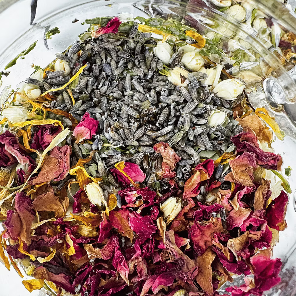 Bowl of dried flowers and herbs including lavender and rose petals.