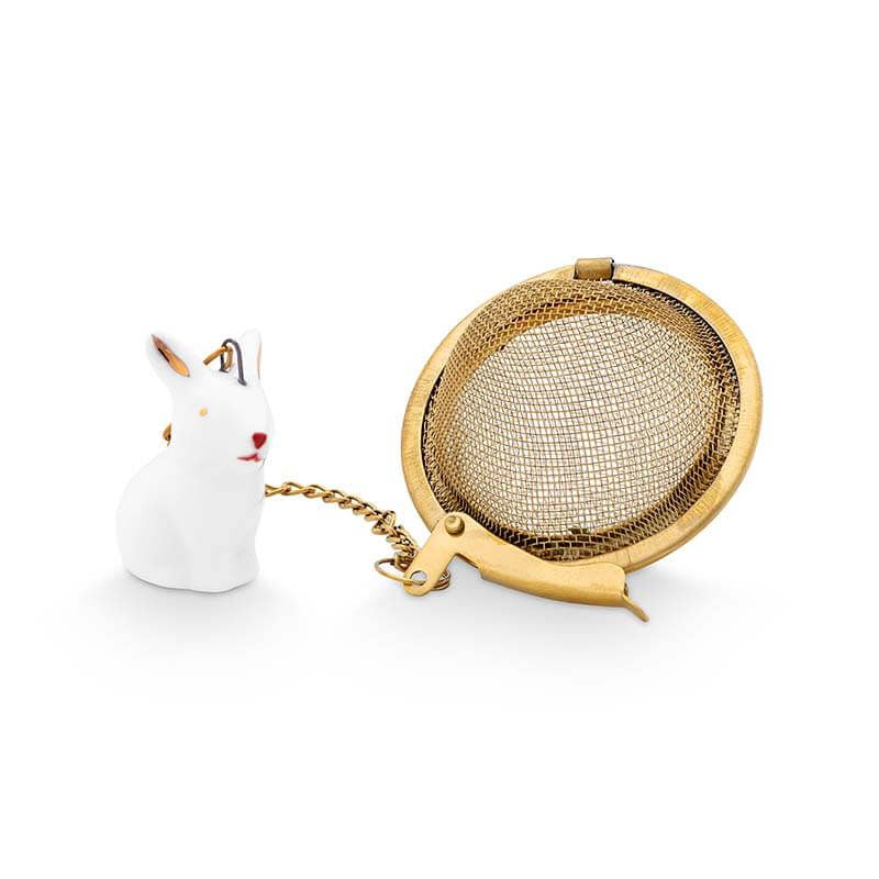 Gold tea infuser with a small white rabbit-shaped container on a white background