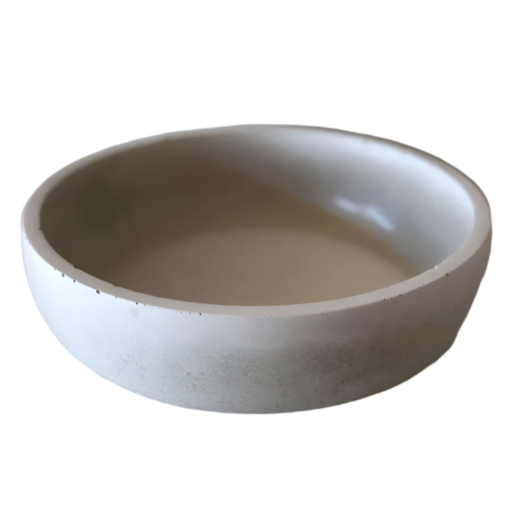 grey concrete bowl on a light wooden surface with a plain background