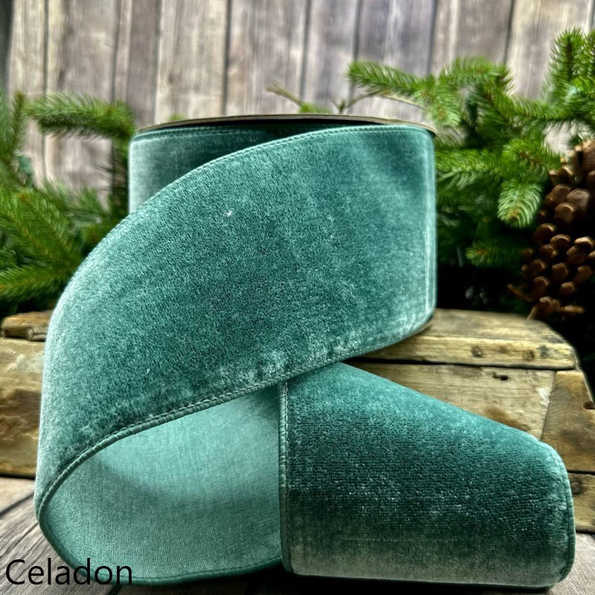 Green velvet cushion on a wooden surface with a natural background