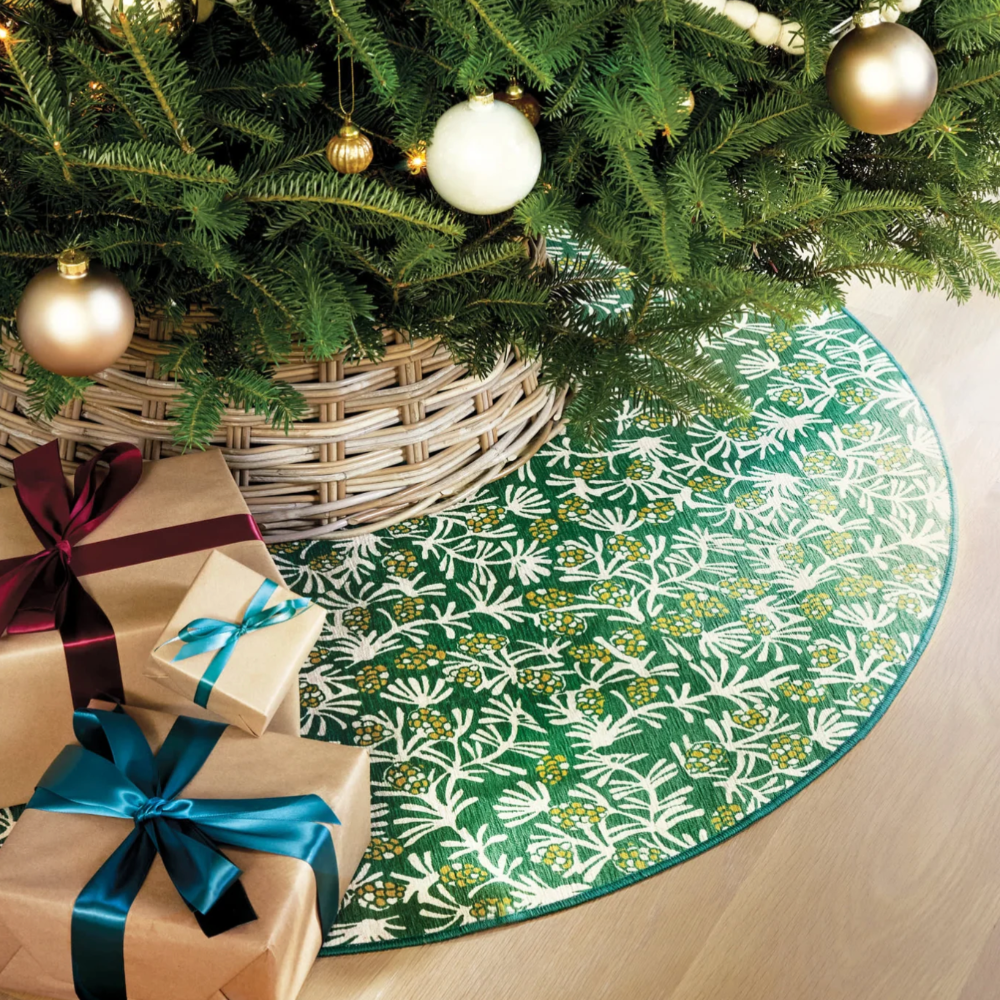 Winter Pinecones Green Machine Washable  Dash and Albert  Round Rug underneath a Christmas Tree at Home Smith