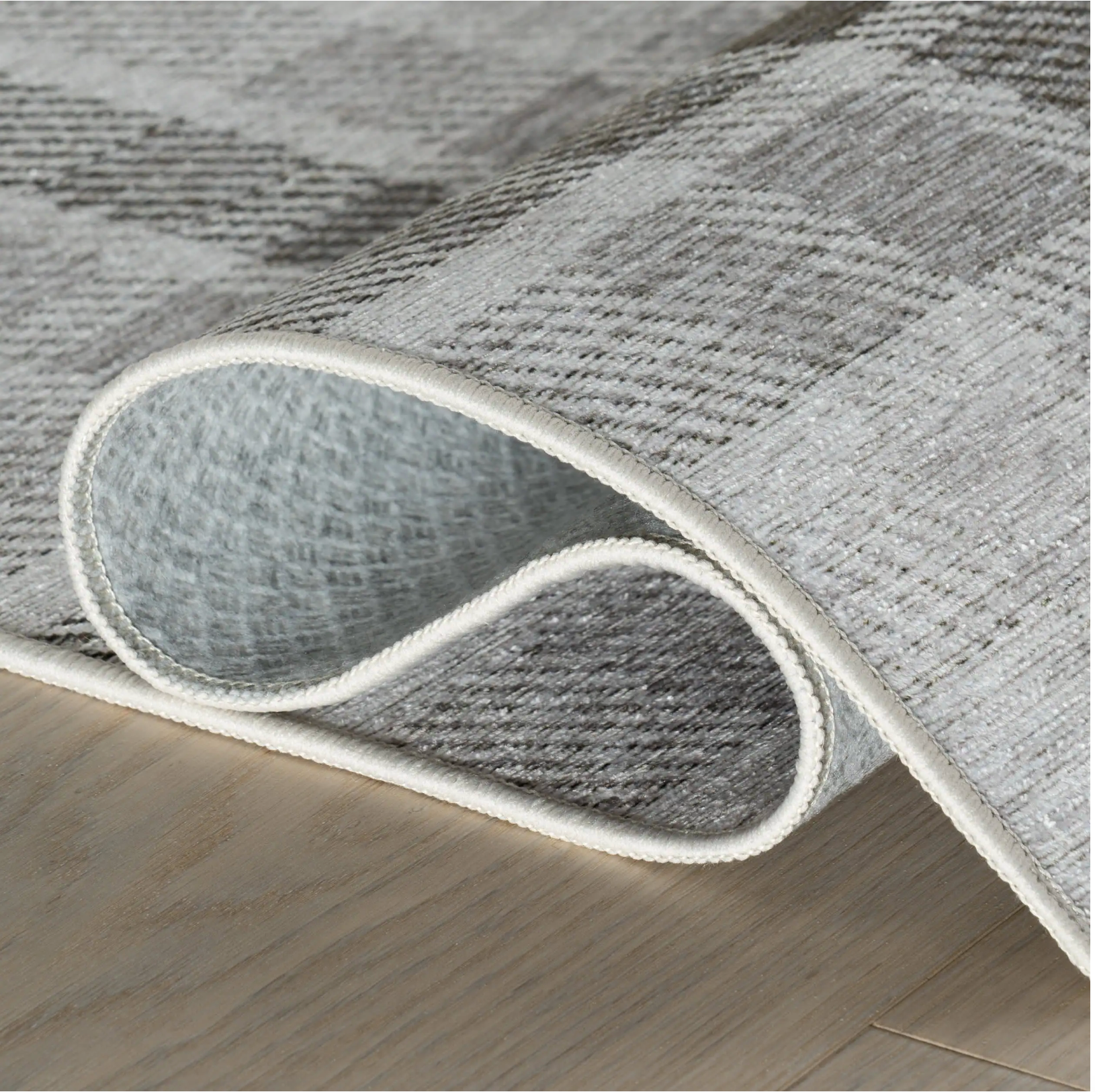 Gray textured area rug on a wooden floor