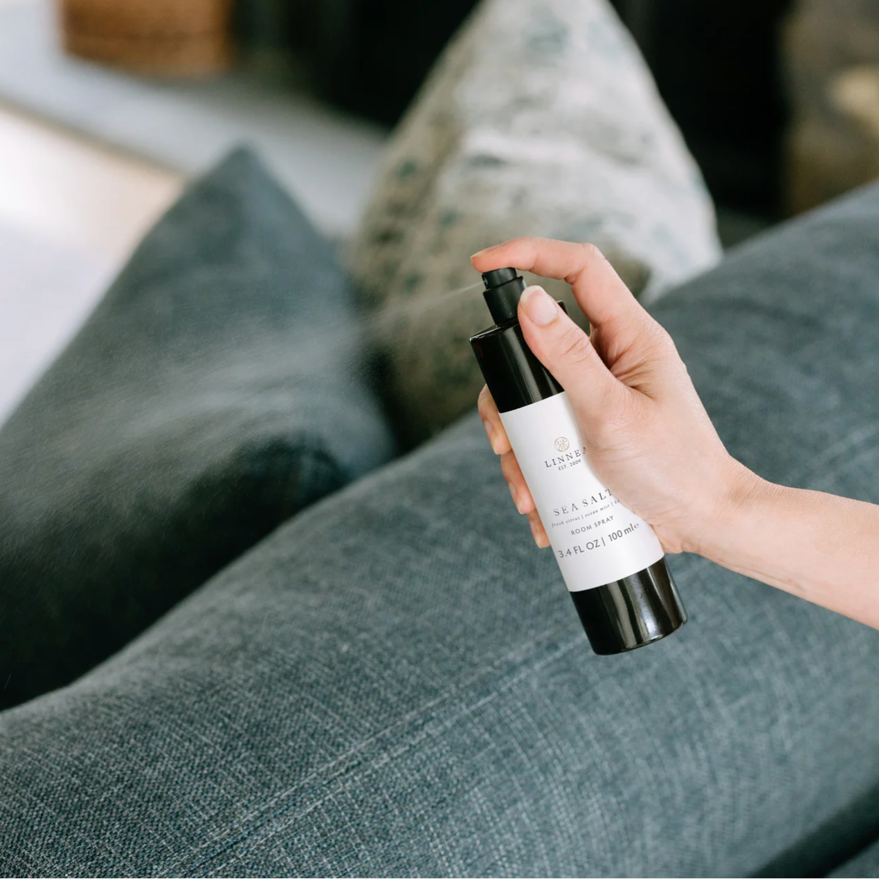 Hand holding a skincare product bottle with a blurred background