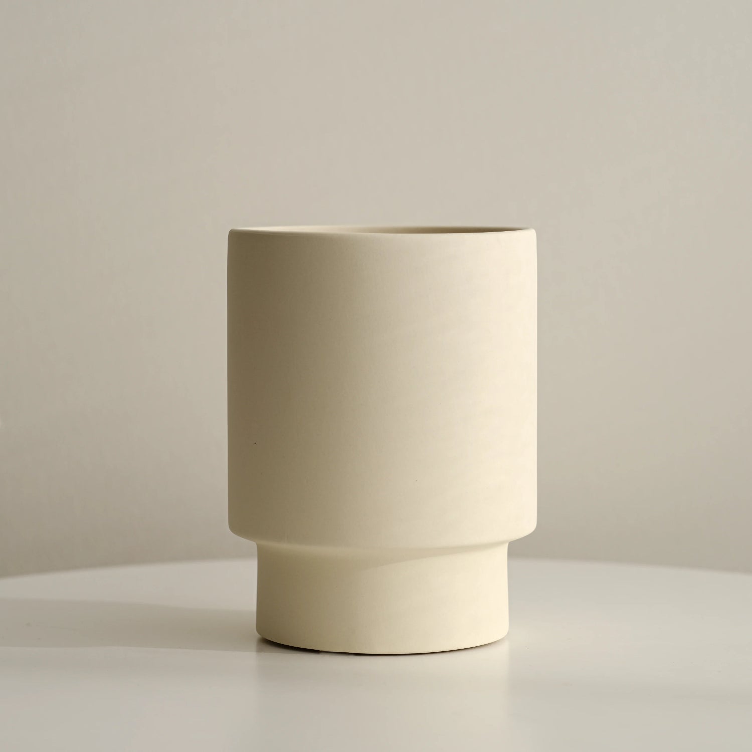 modern ceramic pedestal vase with neutral background